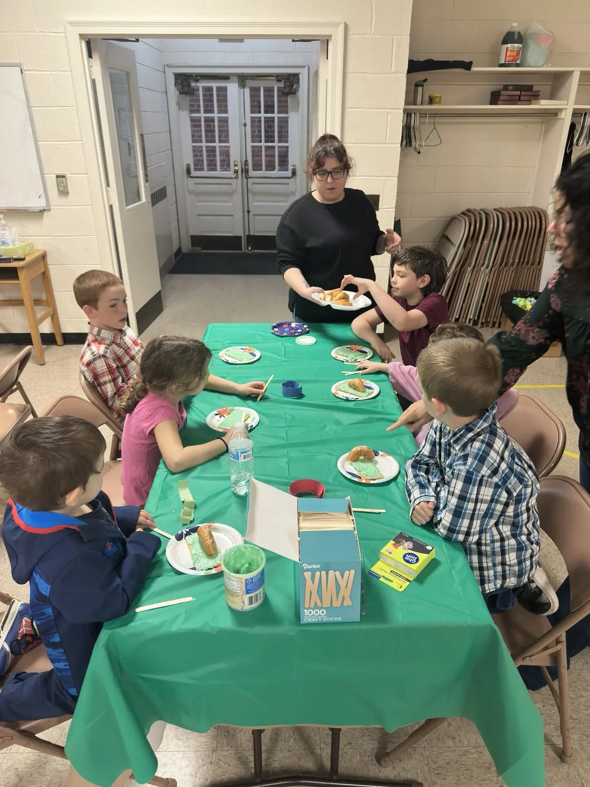 Children sharing food and activities around a table at First Baptist Church